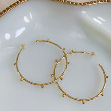 Load image into Gallery viewer, 18k gold filled thin hoop earrings with ball stud detail. Open hoop, push back closure. Lightweight, high quality, tarnish resistant. Shown in 1.75 inches size.