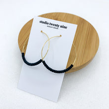 Load image into Gallery viewer, Black beaded gold hoop earrings. Minimalist and lightweight. Small black seed beads are strung on thin 18k gold filled hoops.
