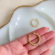 Load image into Gallery viewer, 24k gold filled micro pave spike hoop earrings. 1.5 inch huggies made with clear CZ stones. High quality, tarnish resistant. Shown for size in model&#39;s hand to be the width of almost 2 fingers.
