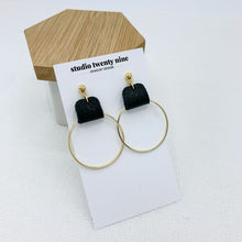 Load image into Gallery viewer, Black and gold earrings made with genuine leather looped on a gold hoop. Minimalist and lightweight for everyday. Ball post stud.
