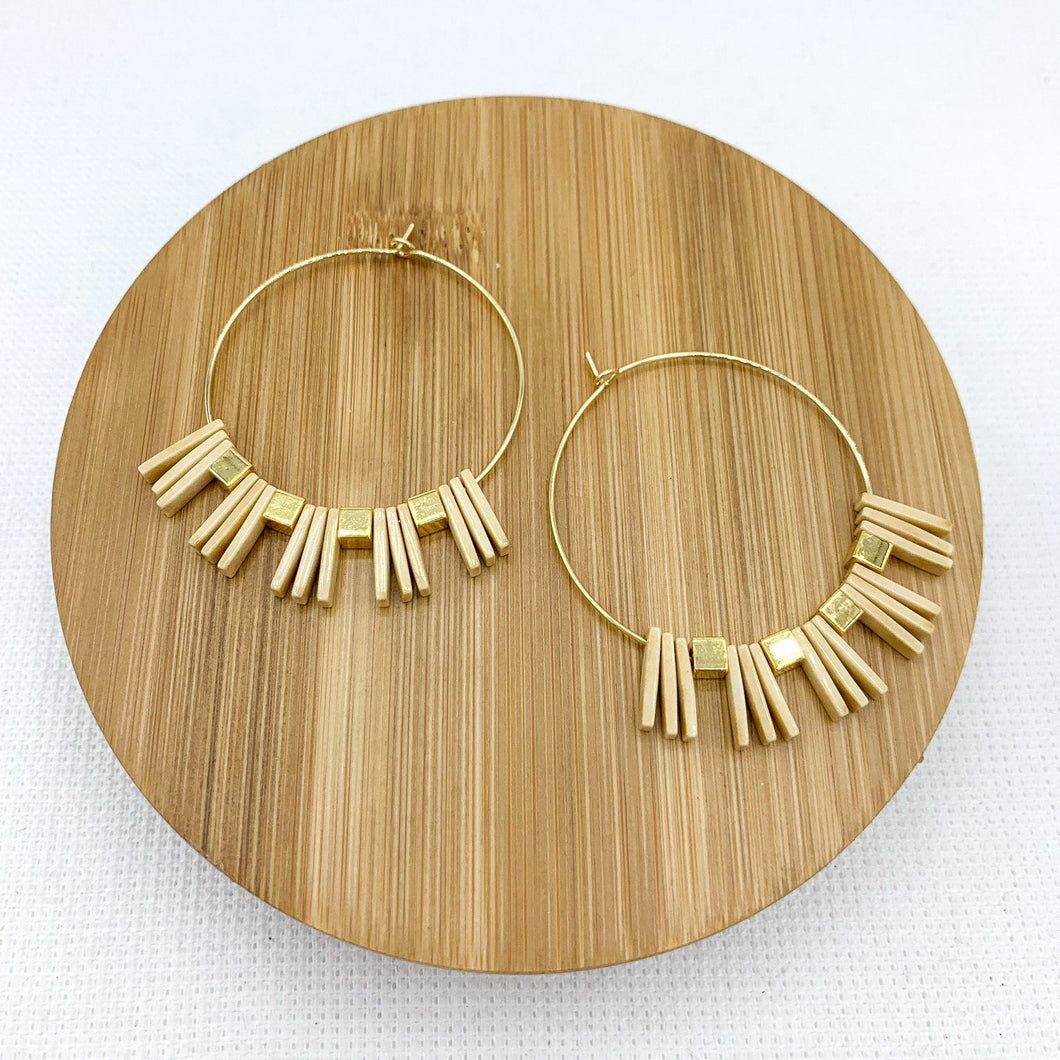 Geometric spiky beaded gold hoop earrings. Rectangle tan beads and square gold beads strung on thin 18k gold filled hoops.