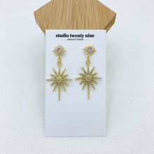 Load image into Gallery viewer, Bold, chic gold starburst CZ dangle earrings with a sparkly style that catches the light in a beautiful way. High quality, hypoallergenic 24k gold plated posts.
