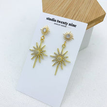 Load image into Gallery viewer, Bold, chic gold starburst CZ dangle earrings with a sparkly style that catches the light in a beautiful way. High quality, hypoallergenic 24k gold plated posts.
